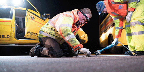 Image showing London Gatwick engineers in high visibility coats installing runway lights at night